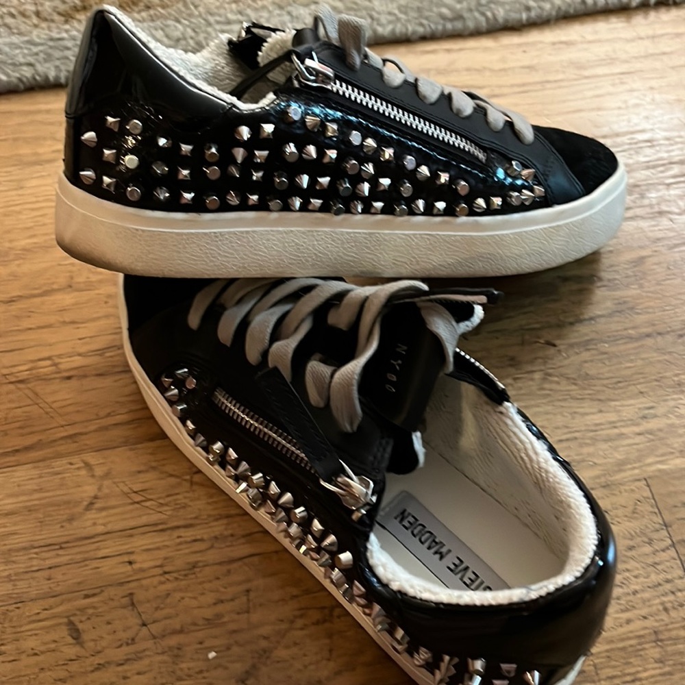 Steve Madden sneakers with zipper and spike details.